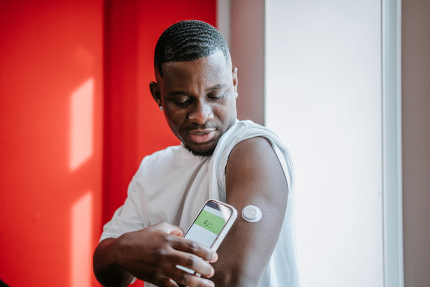 Man using phone to read glucose monitor