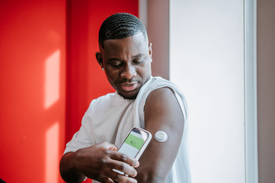 Man using phone to read glucose monitor