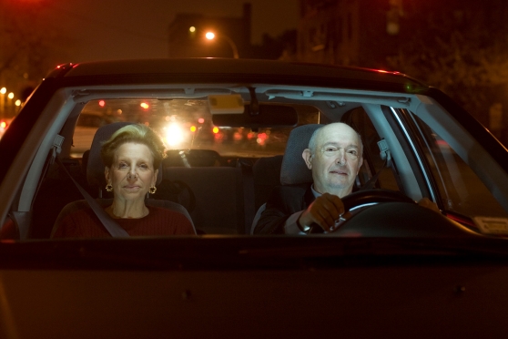 Older couple in a car wondering why seeing at night may be difficult 